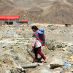 Woman with child in contaminated area in Huanuni, Bolivia